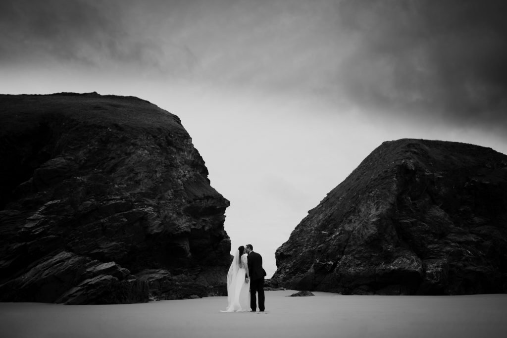 Wedding Couple kiss in middle of rocks on a beach in Cornwall