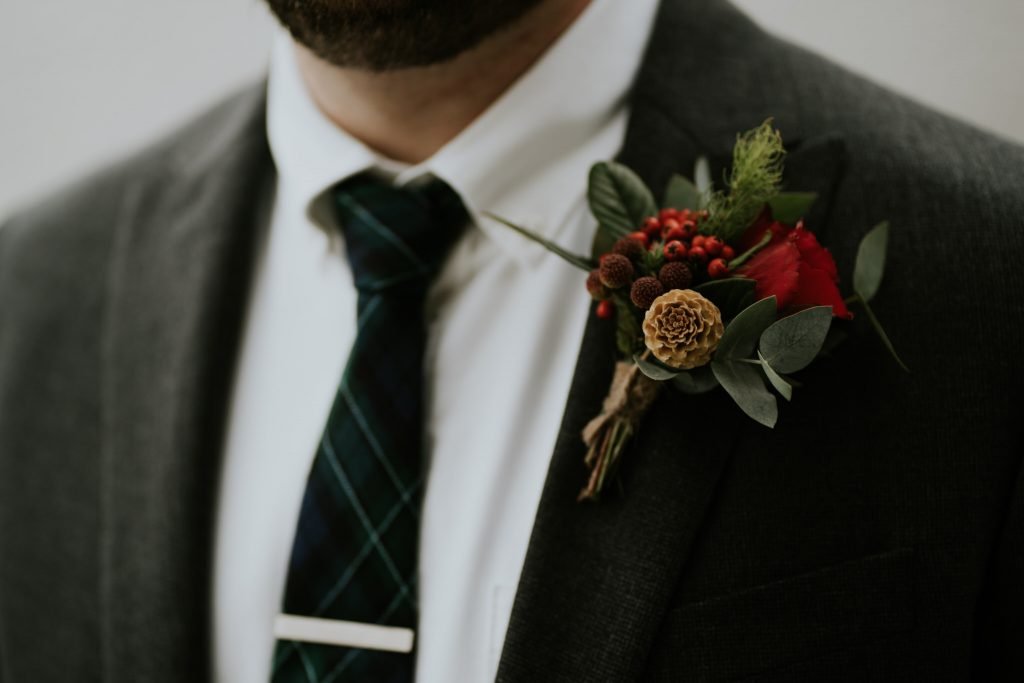 A close up image of a grooms winter buttonhole with dried wild berries and seeds 